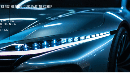 Close-up of a sleek, futuristic car headlight with a blue glow, showcasing the partnership between Honda and Nissan.